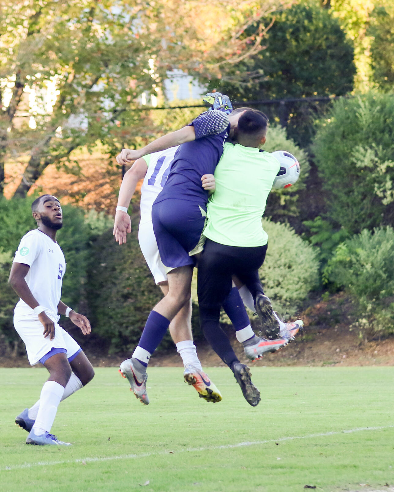 NCISAA 2020 3A Boys Soccer State Championships. Concord Academy's Aydan Patterson (in blue) and Keeper,, Ismael Ortiz (in yellow) collide with a Calvary Day player during a corner kick Joan Moore/Special to the Independent Tribune